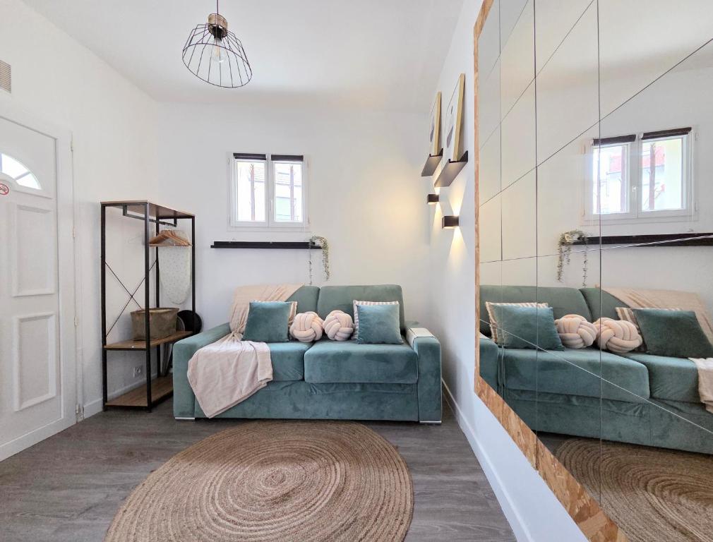 a living room with two green couches and a rug at *Ça me convient* Studio Chaleureux in Villejuif