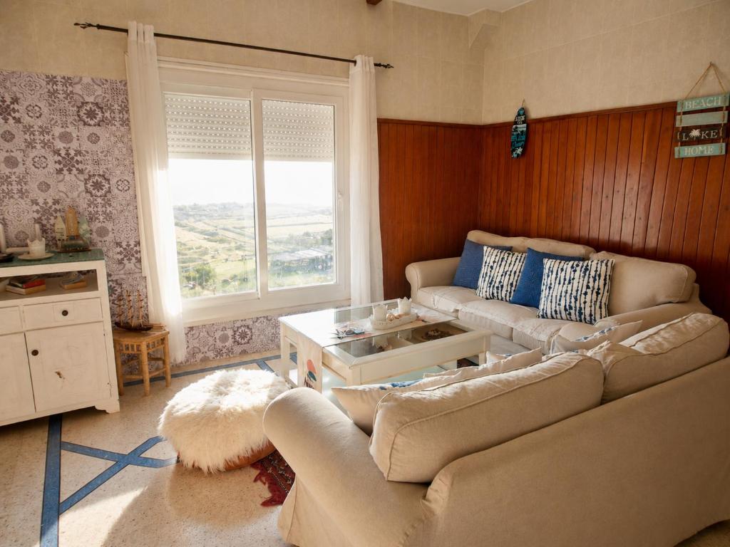 a living room with two couches and a table at HeenaluSurfCamp - ocean view appartement - 4P - Tamraght in Tamraght Ouzdar