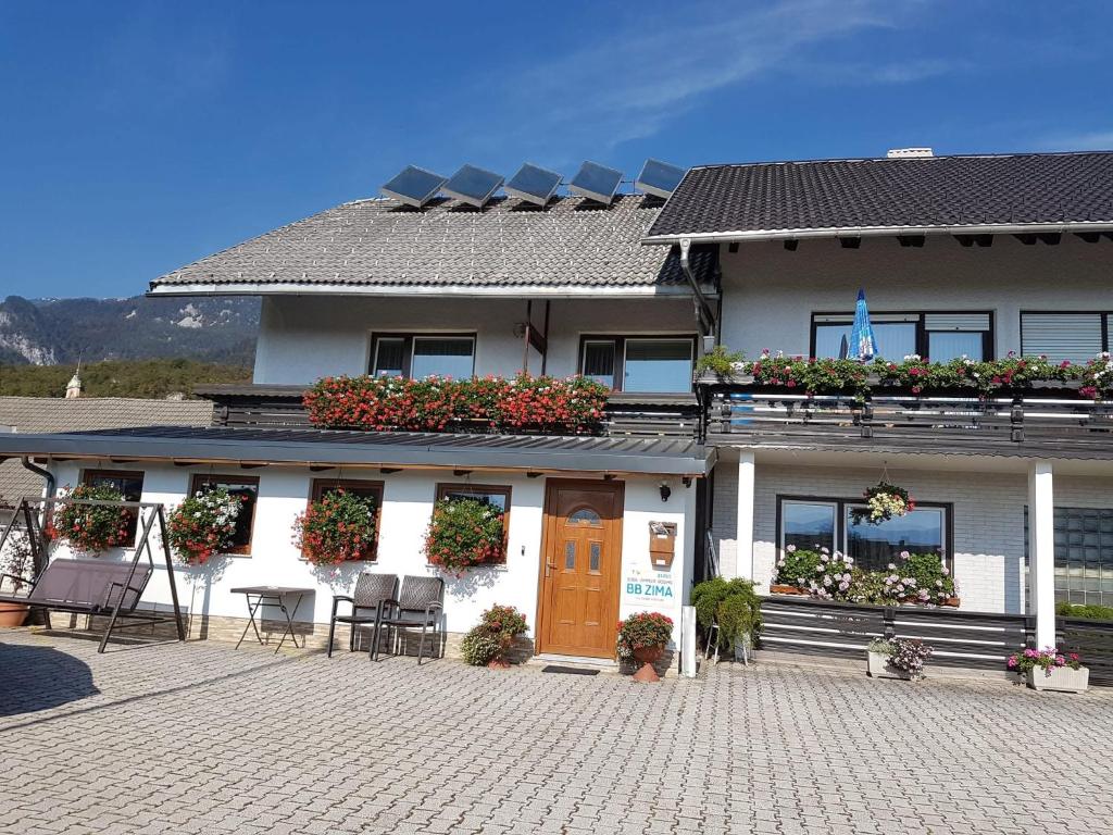 a building with a table and chairs in front of it at Rooms Zima in Žirovnica