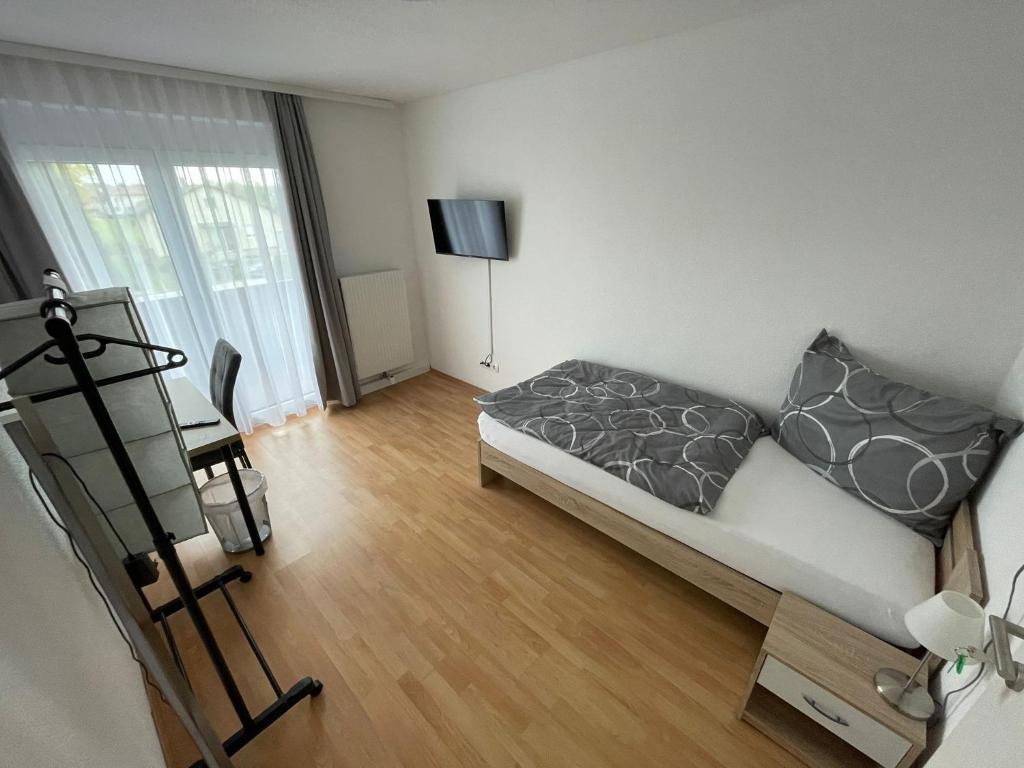 a room with a bed and a desk and a television at GrafOne Apartment in Waizenkirchen