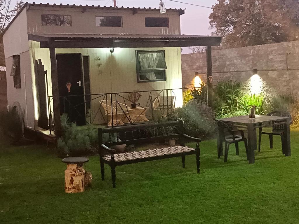 a patio with a bench and a table in a yard at Log in At 118 Log 1 in Meyerton
