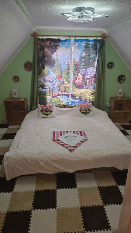 a bedroom with a bed with a painting on the wall at William's Vendégház in Várpalota