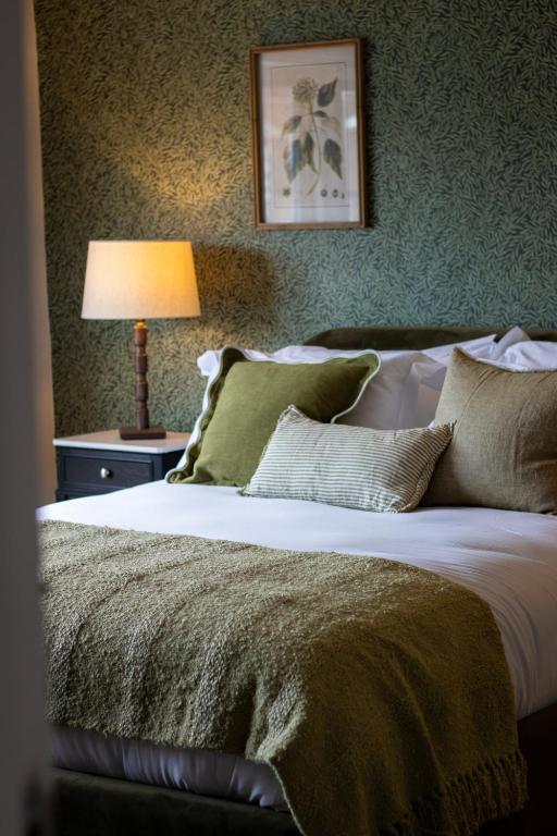 a bedroom with a large bed with green pillows at The Marlborough Inn in Marlborough