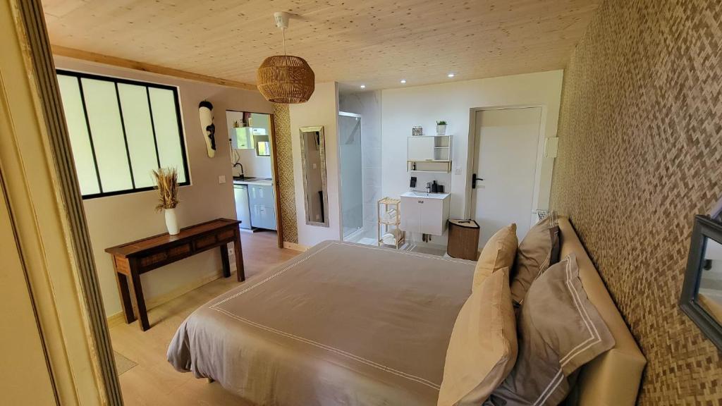 a bedroom with a bed and a table in it at le verger des Sy Pommier in Picauville