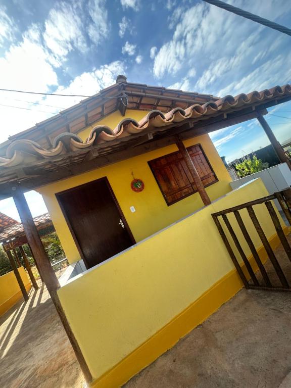 a yellow house with a brown roof at Chalé do coiote 2 in São Roque de Minas