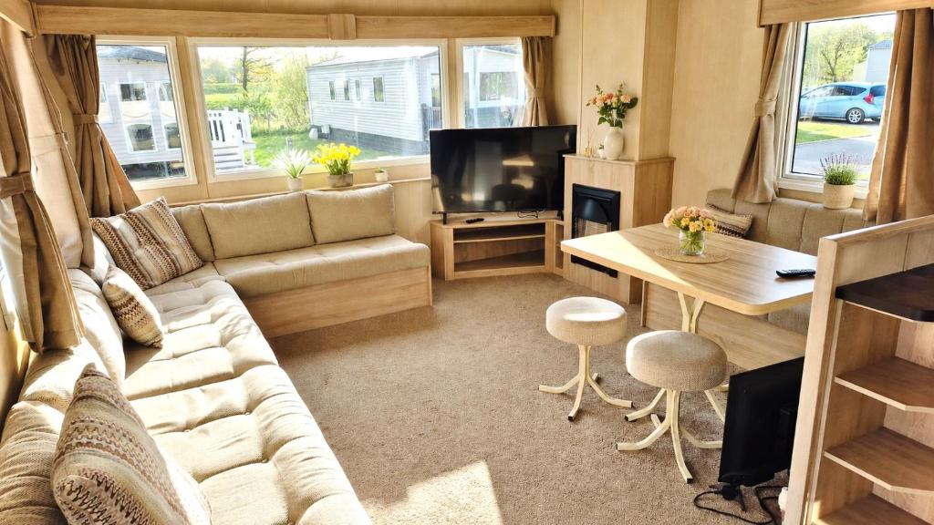 a living room with a couch and a tv at The Pastures 29 Caravan in Tattershall