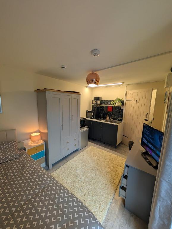 a bedroom with a bed and a desk with a computer at Private Studio Anex in Sherborne Saint John
