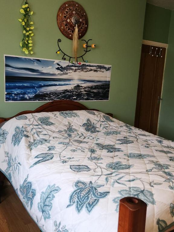 a bedroom with a bed with a blue and white comforter at Hideaway Retreat 1 & 2 in Belvedere