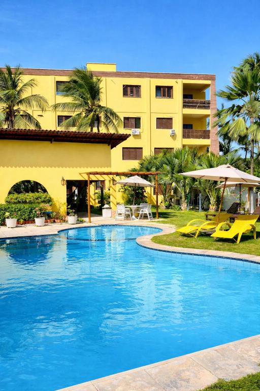 a hotel with a swimming pool in front of a building at Pousada Sunrise Beach in Cumbuco