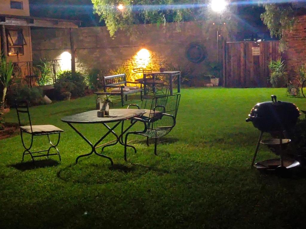 a patio table and chairs in a yard at night at Log in At 118 Loghome in Meyerton