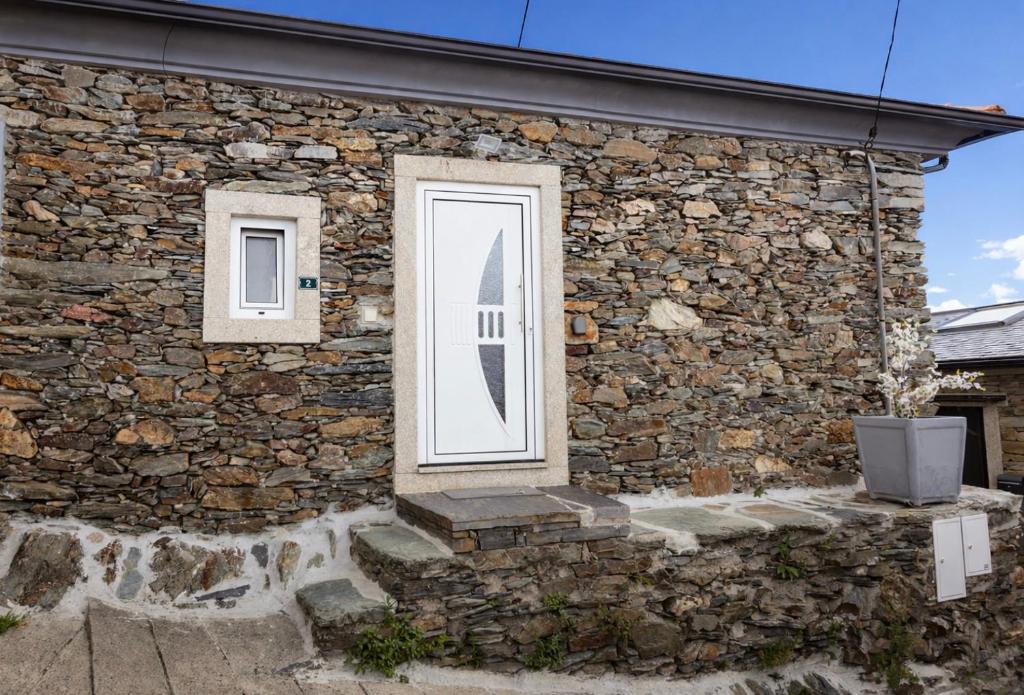 a stone building with a window and a television at Casa Saudade Vila Real North in Vila Real