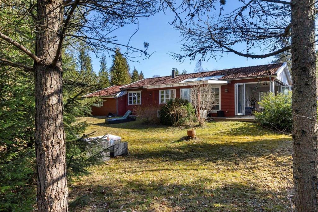 a red house with trees in front of it at 84300-Ebeltoft-Bogfinkevej-17 in Fuglslev