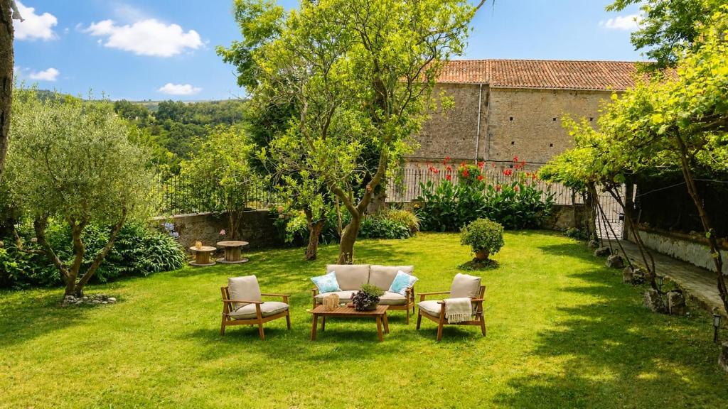 a garden with chairs and a table and a table and chairs at Casa La Portilla in Labarces