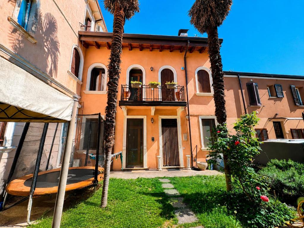 a house with palm trees in front of it at Palazzo Degli Affreschi - Luxury Villa Verona in Verona