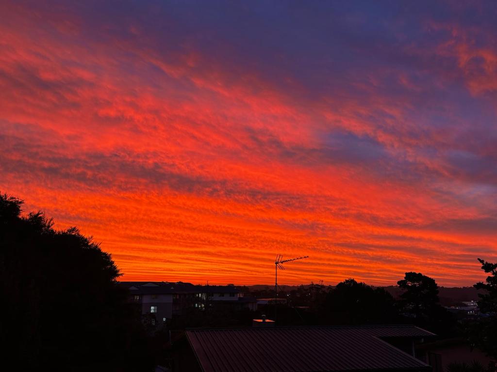 a sunset with a red sky at Sunsets over Unsworth in Auckland