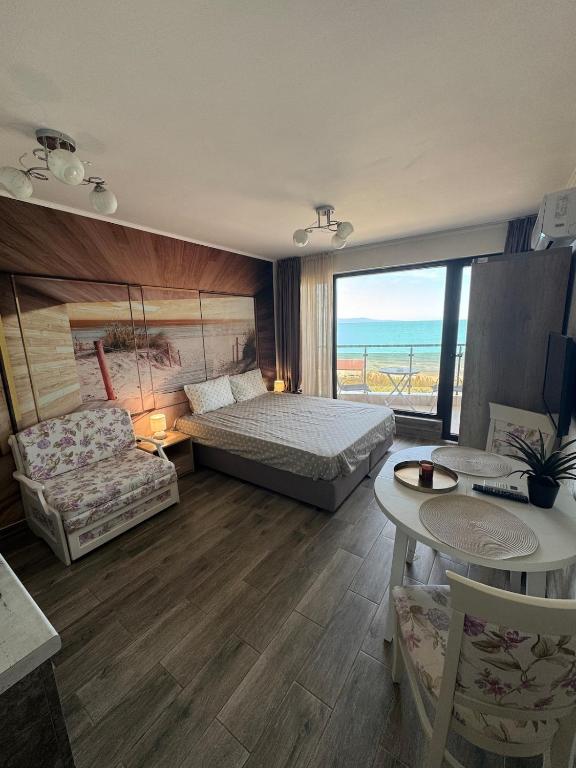 a bedroom with a bed and a couch and a table at Infinity Sea View Studio in Pomorie