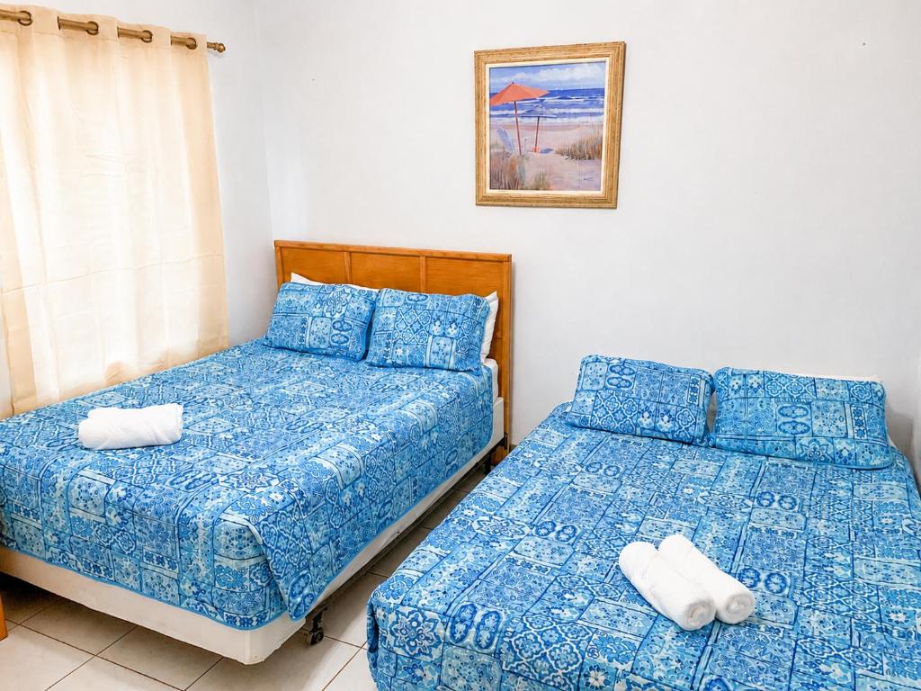 two beds sitting next to each other in a bedroom at SUITE 1, BLUE PAVILION - Steps to BEACH - NEW AC in West Bay