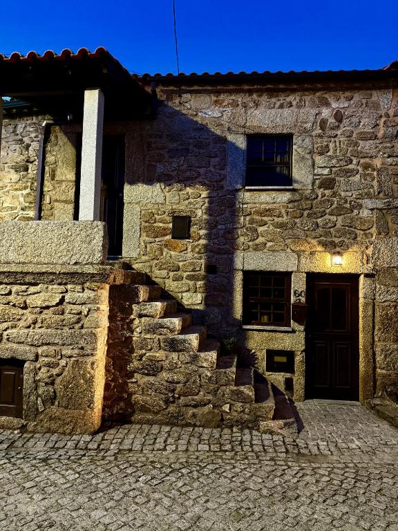 a stone building with stairs in front of it at Casa D Dinis in Alfaiates