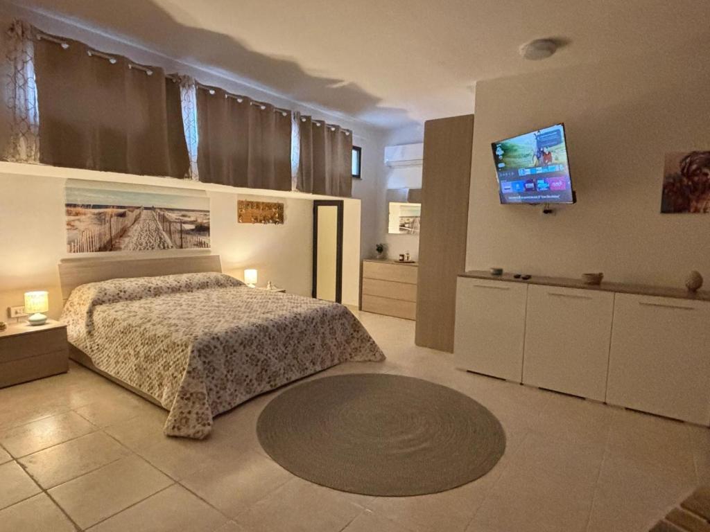 a bedroom with a bed and a flat screen tv at Villa Xenia in Pizzo