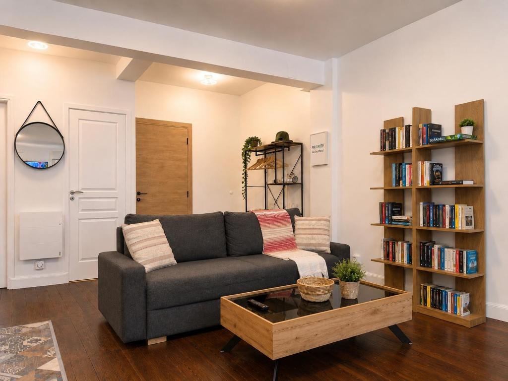 a living room with a couch and a book shelf at Cosy Normandy - Bloom in Sourdeval