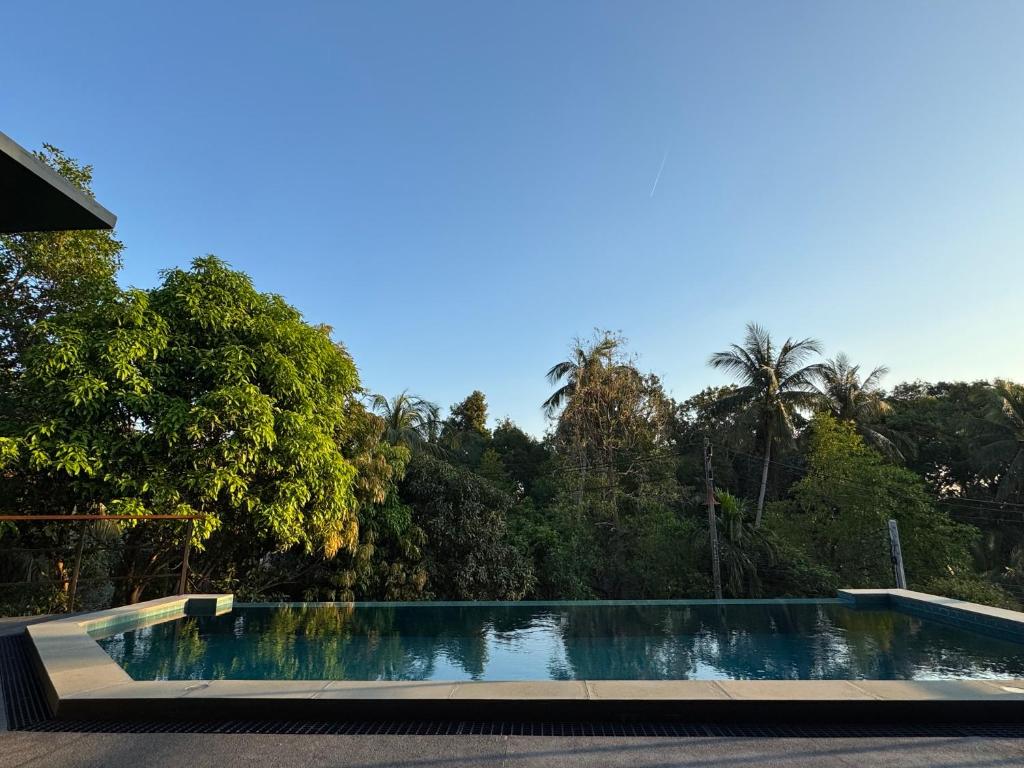 a swimming pool with trees in the background at DeerWood villa in Hinkong