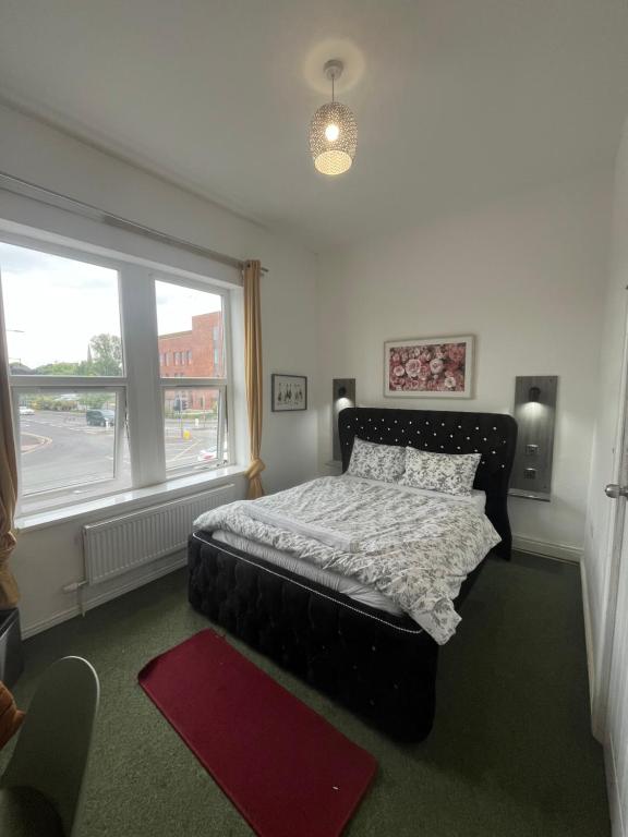 a bedroom with a bed and a large window at Eva lodges in Manchester