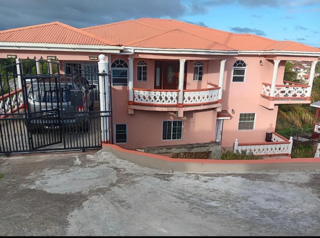 a pink house with a gate in front of it at Prospect Loft in Kingstown