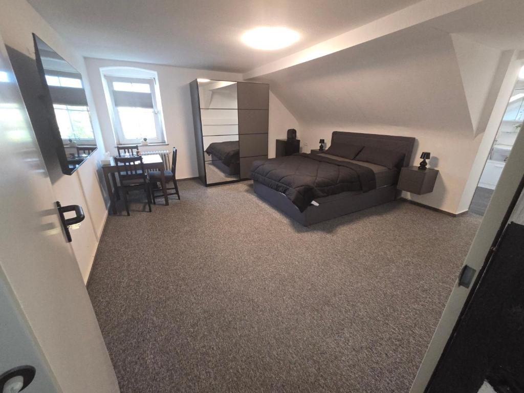 a bedroom with a bed and a table and chairs at M-NOUr in Solingen