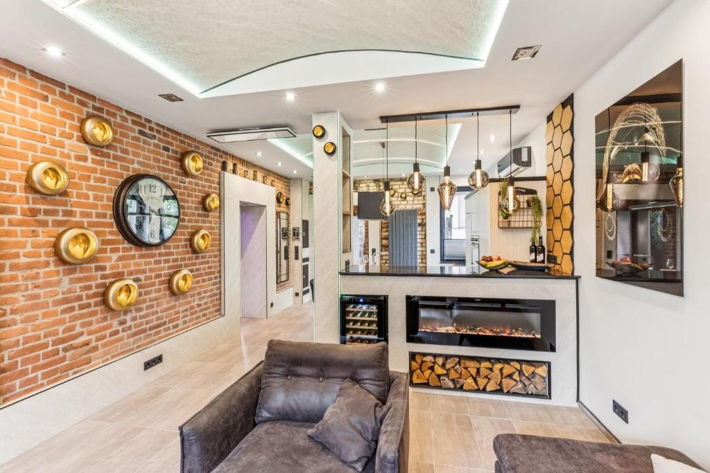 a living room with a couch and a brick wall at Ambiente Apartment in Olfen