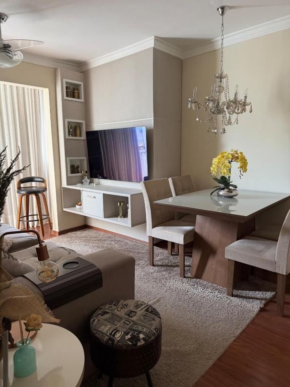 a living room with a table and a dining room at Apartamento Serra Espírito Santo in Serra