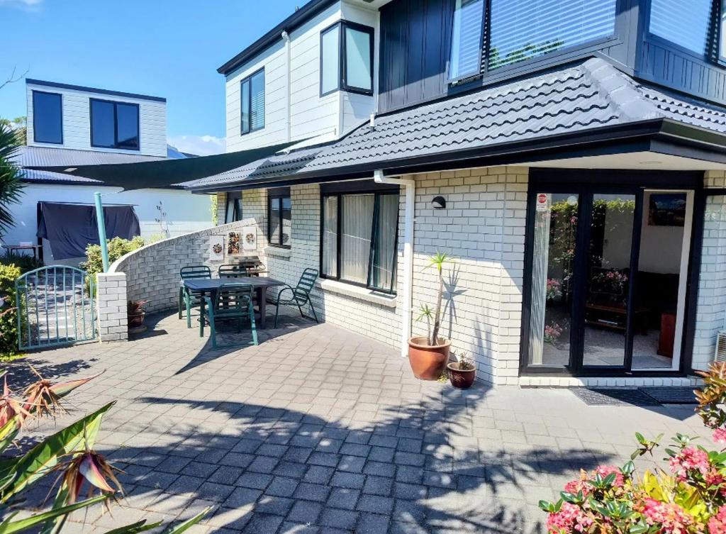 a patio of a house with a table at Mount Handy Dandy in Mount Maunganui