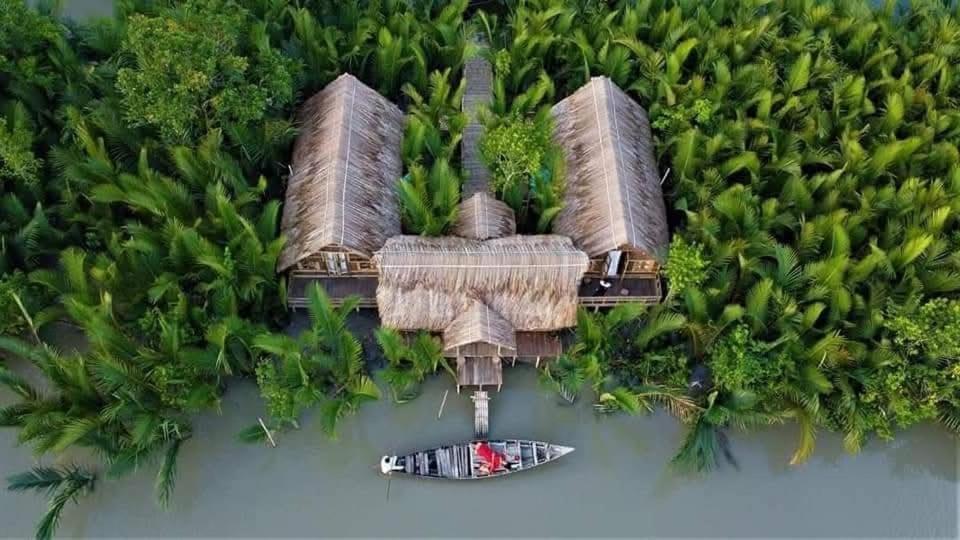 an aerial view of a house in the water with a boat at Iraboti Eco Resort Sundarban in Dhāngmāri Forest Office