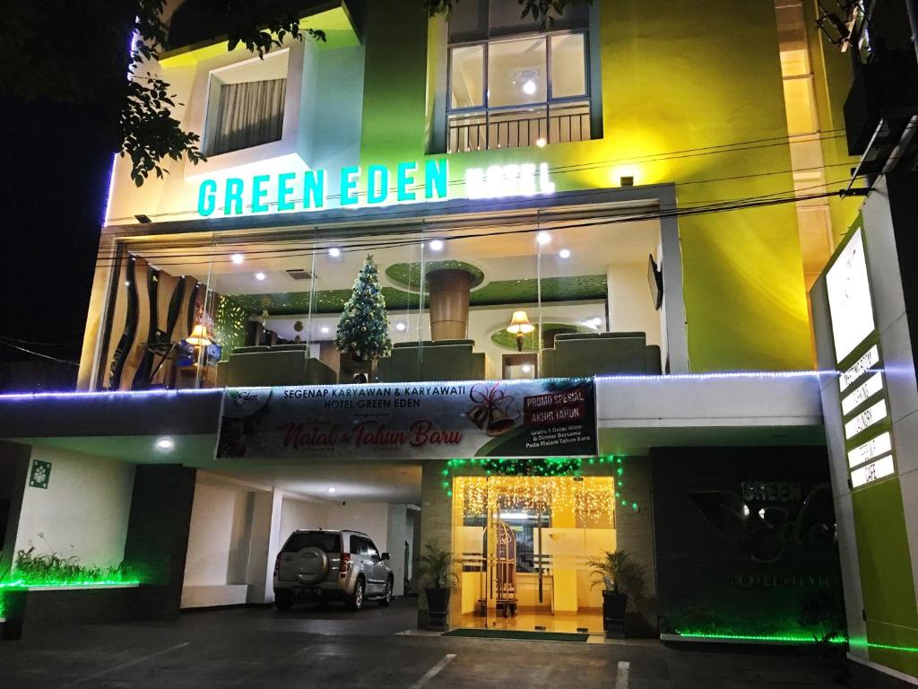 een greenbell hotel 's nachts met een auto geparkeerd voor de deur bij Green Eden Hotel in Manado