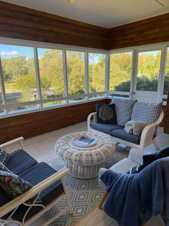 a living room with couches and a table and windows at Namoi Dreaming Spacious parkview residence in Narrabri