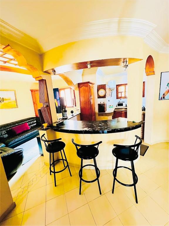 a kitchen with a island with four bar stools at Vintage apartment EL JADIDA in El Jadida