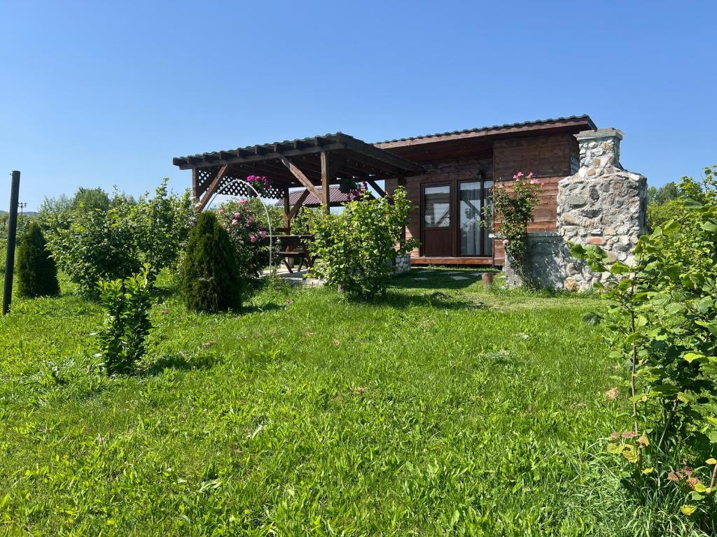 a house in the middle of a grassy yard at The Orchard Manor in Ociu