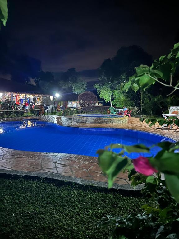 a large blue swimming pool at night at Finca Hotel Cabaña Fercho in Quimbaya