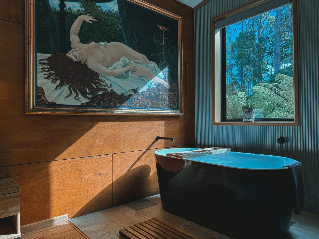 a bathroom with a large painting and a bath tub at The Little Seed in Franklin