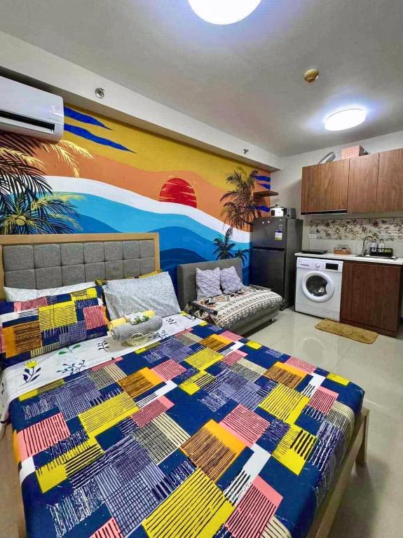 a bedroom with a bed with a colorful quilt on it at Saekyung Condominium in Suba