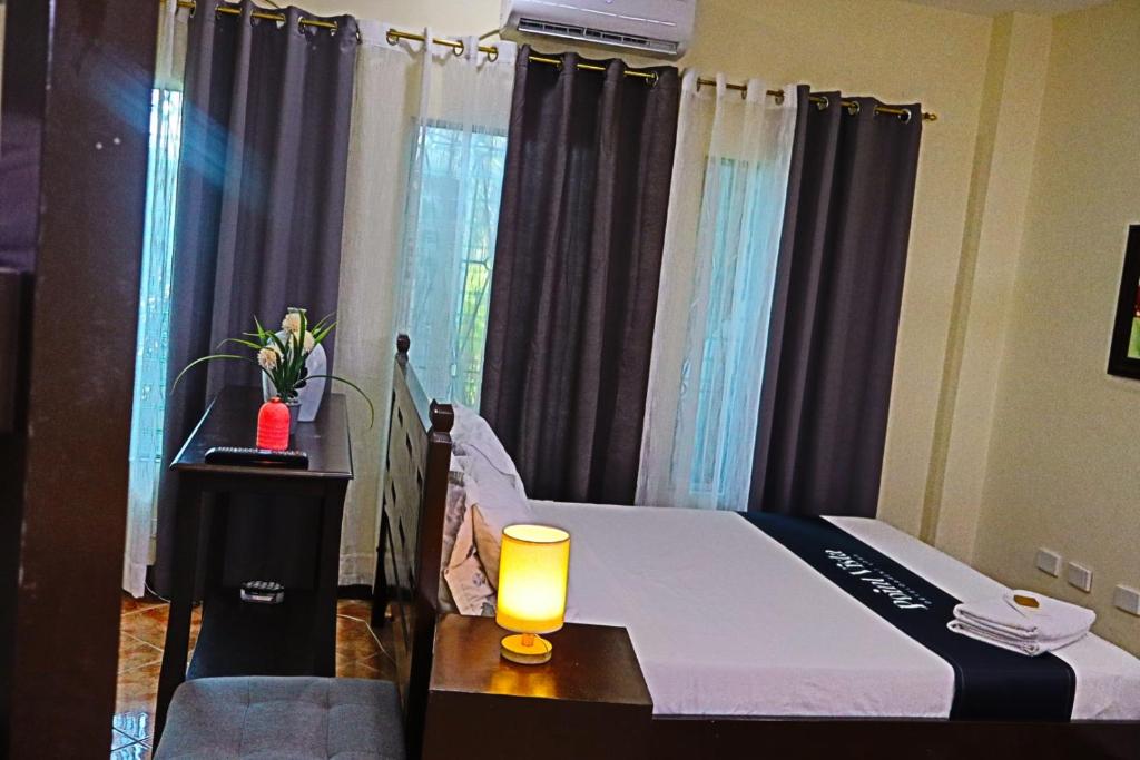 a bedroom with a bed with a candle on a table at Point Vista Transient Accomodation in Daet