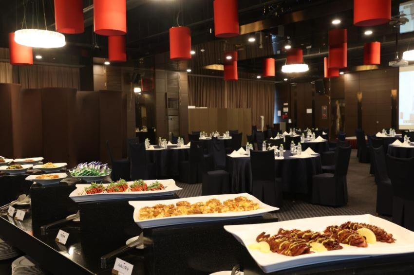 a restaurant with several plates of food on a table at Hotel Laonzena in Daegu