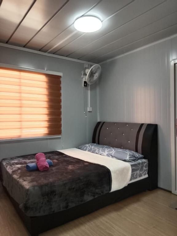 a bedroom with a bed with a stuffed animal on it at K2K Studio Homestay in Ranau