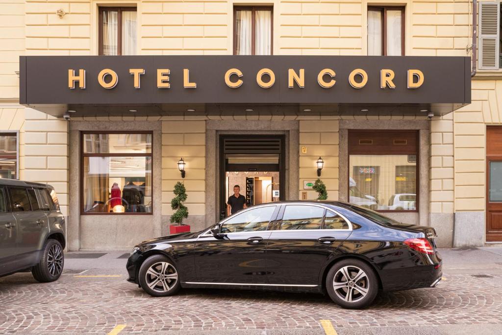 a black car parked in front of a hotel concord at Hotel Concord in Turin