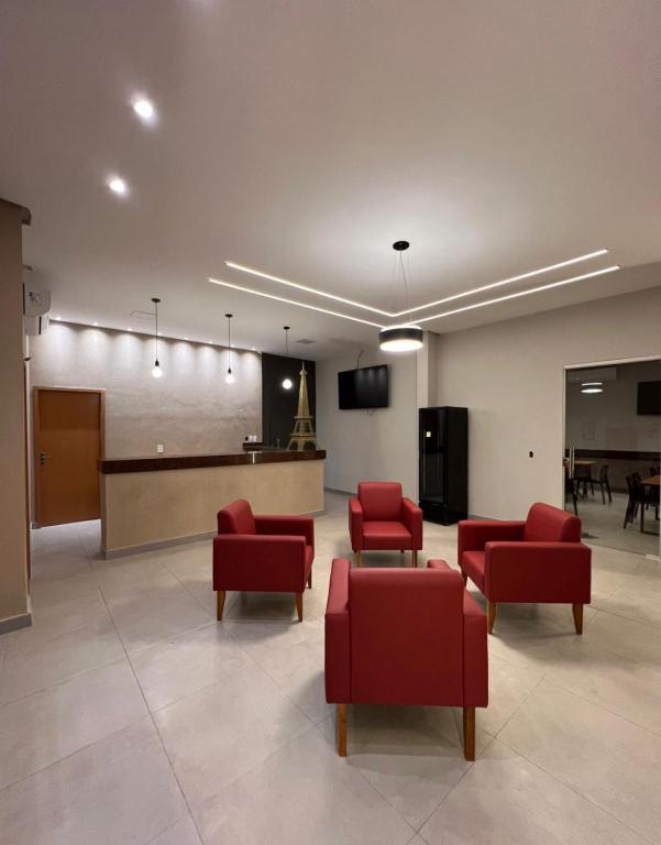 a waiting room with red chairs and a table at Hotel Paris in Balsas