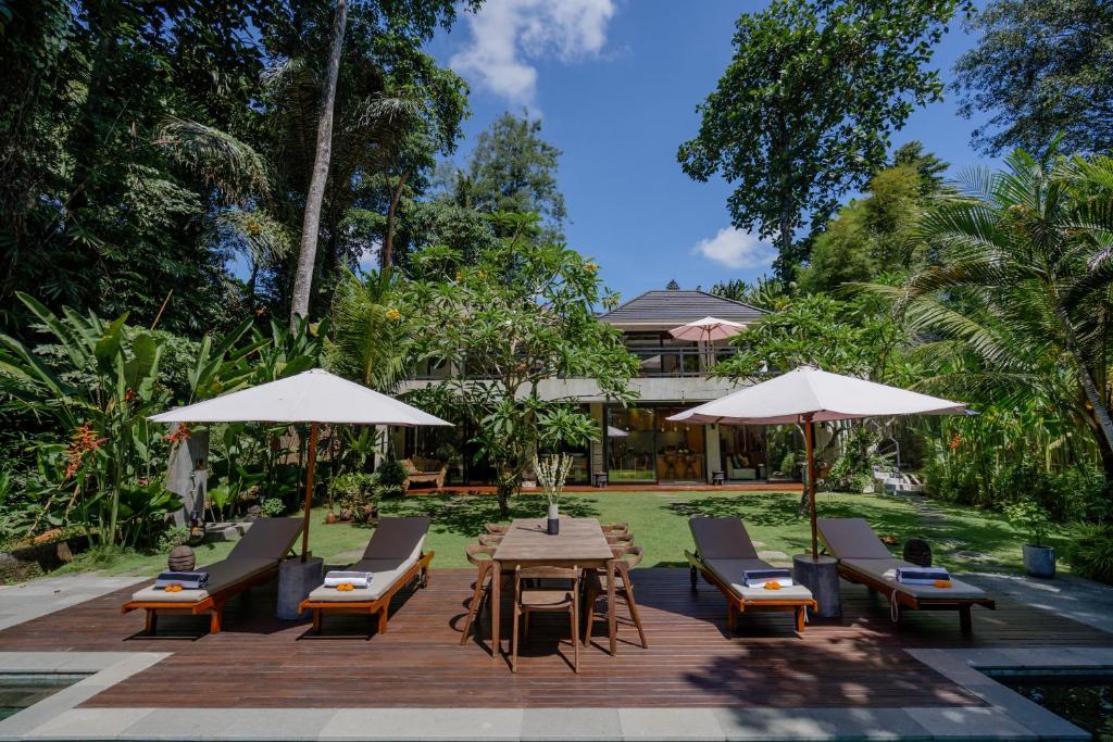 a patio with chairs and tables and umbrellas at San Michele Villa in Dalung