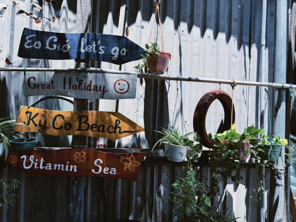 a group of signs on a fence with plants at TRI'S Homestay in Quy Nhon