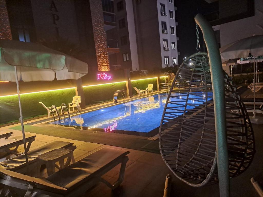 a swimming pool with a hammock and a swing at Neridabeachhomes 20 in Alanya