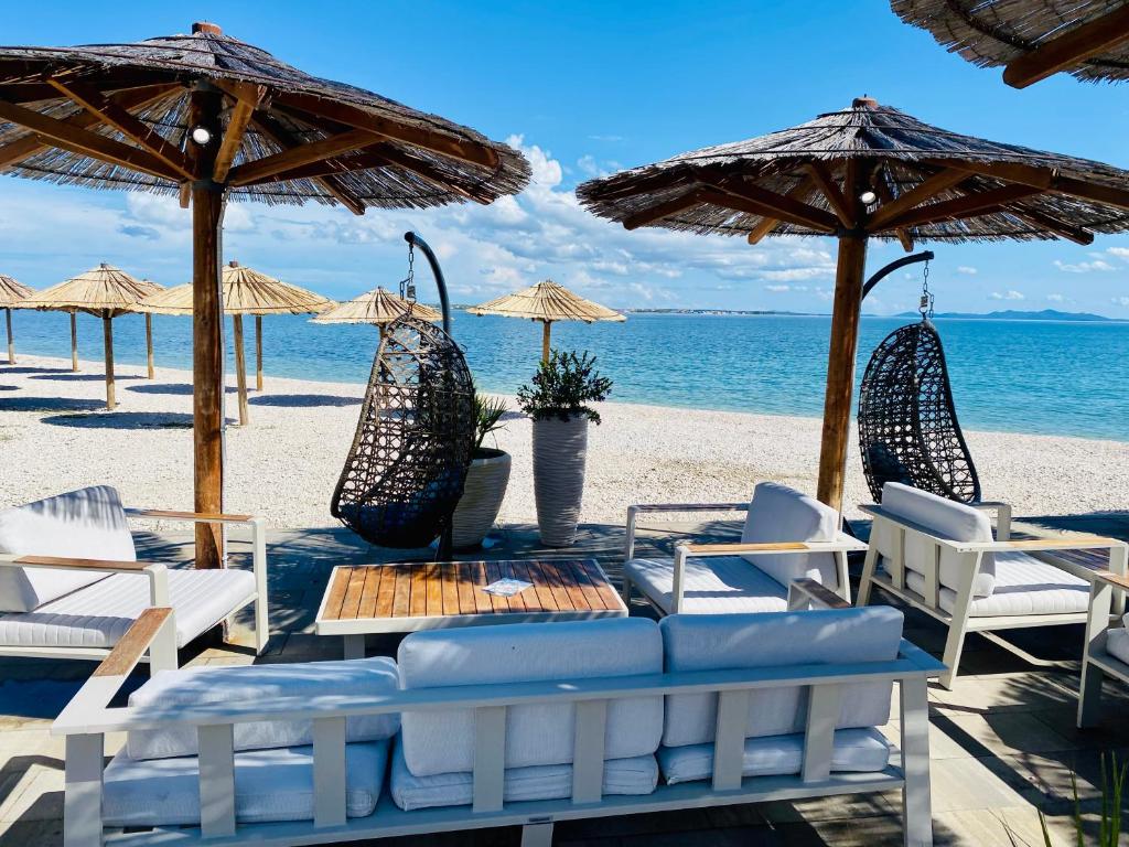 a table with chairs and umbrellas on a beach at Apartmany Vir DaRa in Vir