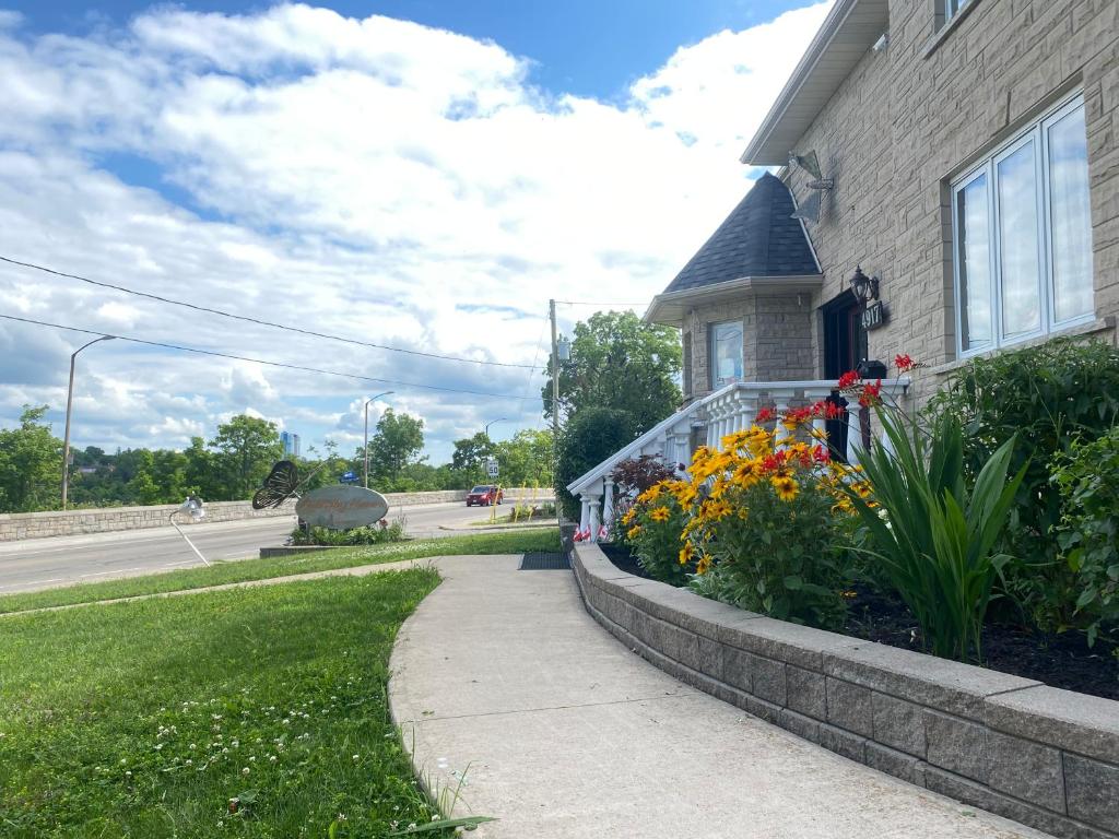 a house with flowers on the side of a sidewalk at Butterfly Manor in Niagara Falls