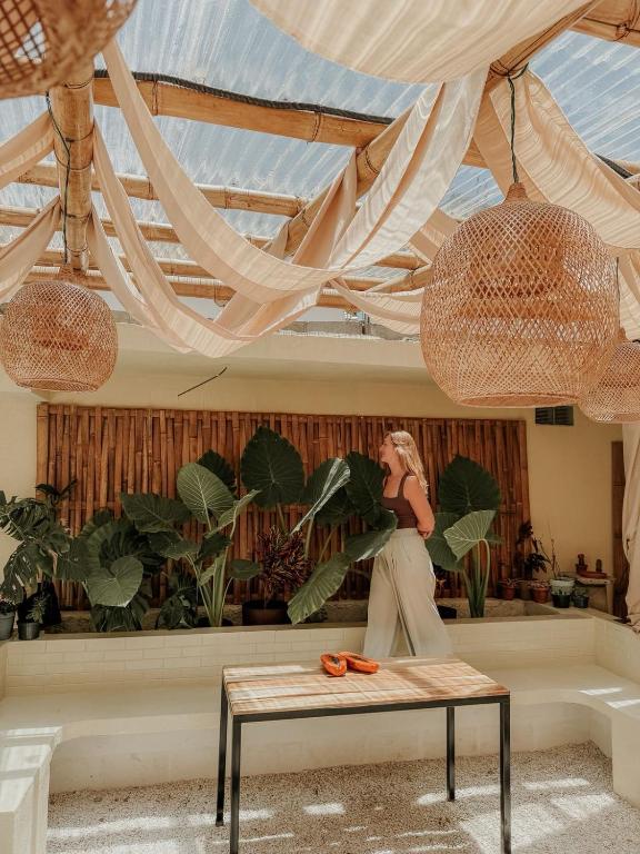 a woman sitting on a bench in a room with plants at Zu Suites in San Marcos La Laguna